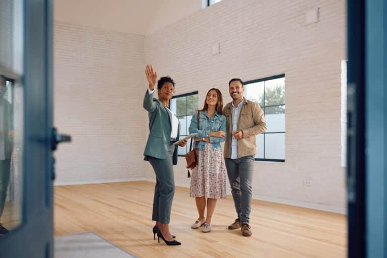 Black real estate agent showing property to her clients.