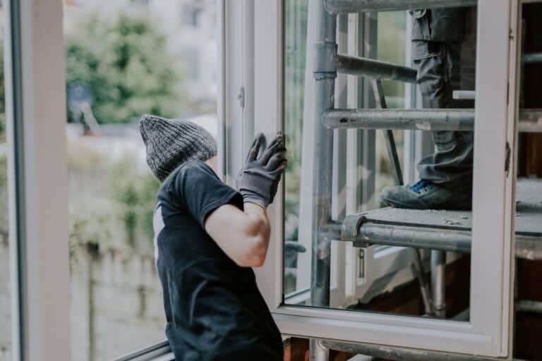 One guy builder helps install a window frame.